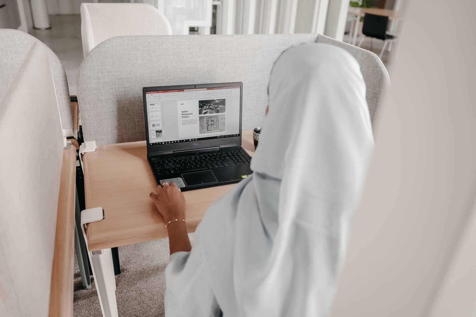 العمل على حاسوب محمول عند أحد المكاتب المفتوحة في مزج